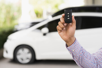 Close up car keys and remote control car alarm systems hold in hand. Young man buy the new car.