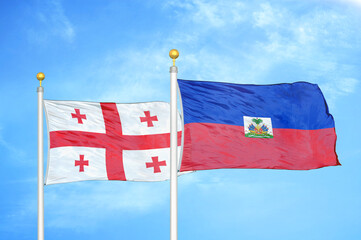 Georgia and Haiti two flags on flagpoles and blue sky