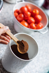 Mit einem Holzlöffel Kaffee aus der Dose holen