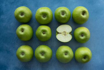 Bright green apples on blue background.