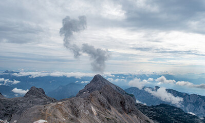 A volcanic mountain spews fog from the top