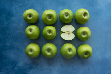 Bright green apples on blue background.