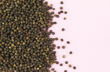 Black pepper on pink background. Copy space for text.