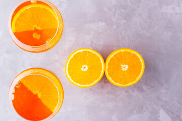 Aperol spritz cocktail on a gray background. Two glasses of aperol spritz with orange slised. Summer cocktail in glass. Top view. Copy space