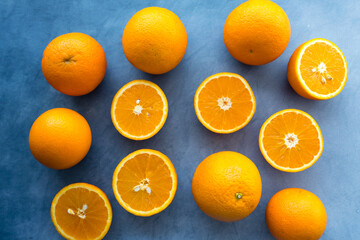 Set of fresh whole and cut orangeon blue background. From top view