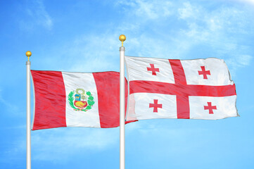 Peru and Georgia two flags on flagpoles and blue sky