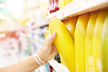 Orange juice in hands buyer in shop