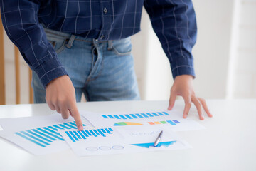 Hand of young business man pointing document data graph and chart paper, marketing and investment, report of statistics profit for financial, economic and growth of finance, management and planning.