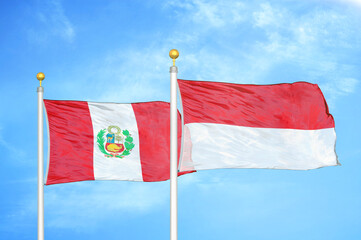 Peru and Indonesia two flags on flagpoles and blue sky