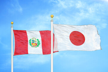 Fototapeta na wymiar Peru and Japan two flags on flagpoles and blue sky