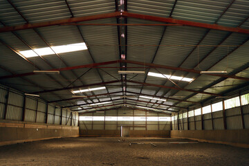 Empty riding hall with sandy covering without riders as an equestrian background