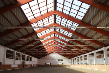 Empty riding hall with sandy covering without riders as an equestrian background