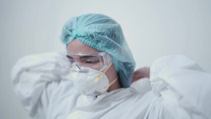 Asian female doctor put on ppe suit, personal protective equipments white medical suit, protective glasses, n95 mask, pandemic covid-19 infection, medical personnel in the hospital, white background - Powered by Adobe