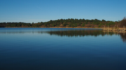 Vue dégagée sur un lac très plat, d'un bleu intense