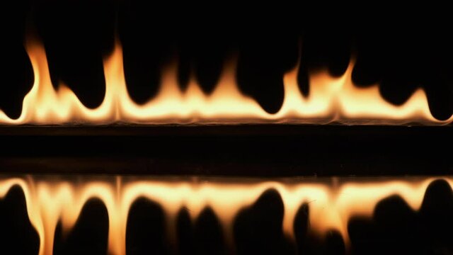 Slow motion, pulsating fire and its reflection on a black background.