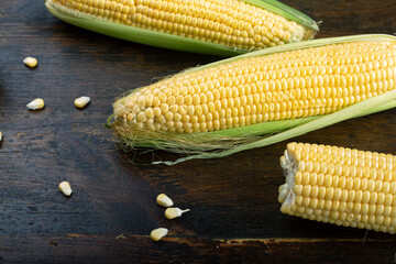Fresh corn on cobs on rustic wooden table