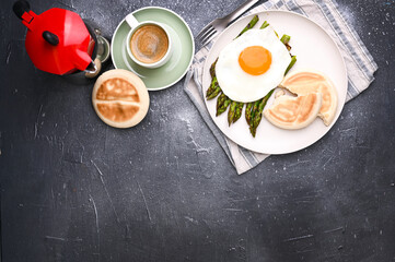 Healthy breakfast. Fried eggs, asparagus, bread and aromatic coffee on a gray background. Free place for text. Soft focus. Above. High quality photo