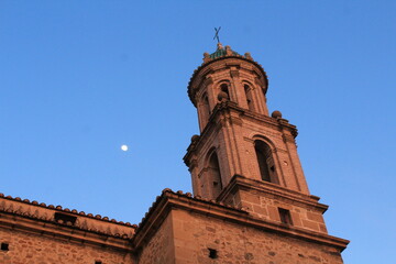Fototapeta na wymiar The moon appears over the bell tower