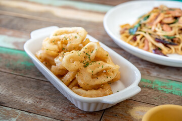 Fried squid with garlic, crispy batter, Asian street food on a wooden floor. Photos jpg