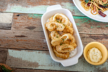 Fried squid with garlic, crispy batter, Asian street food on a wooden floor. Photos jpg