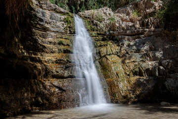 Fototapeta na wymiar Waterfall in the desert – part of the Ein Gedi oasis natural reserve in southern Israel. Long exposure shot.