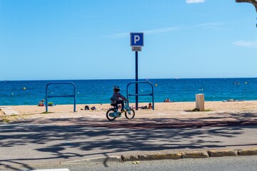Enfant sur un vélo a coté d'une plage