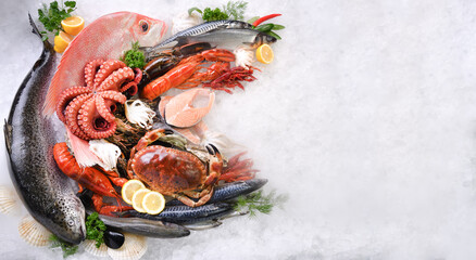 Top view of variety of fresh fish and seafood on ice with copy space
