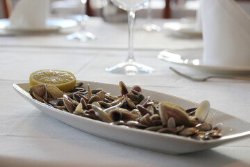 Coquinas dish with a lemon slice. The coquina (Donax trunculus) is a mollusk