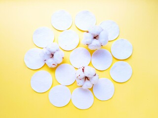 Cotton cotton discs on a yellow background. Personal hygiene and care. Medicine and cosmetology.