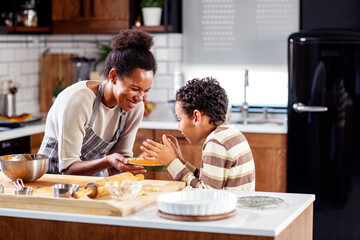 Obraz na płótnie Canvas Mother with his son prepare pie in the kitchen