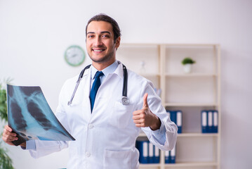 Young male handsome doctor working in the clinic