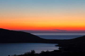 Sunset at Delfini bay, in Syros island, Cyclades, Greece, Europe.