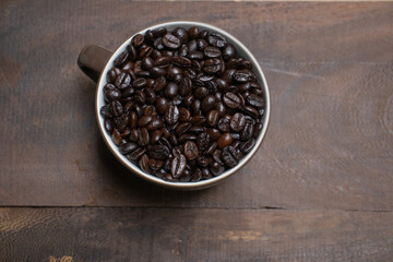 coffee beans in cup on wooden background