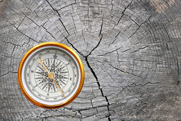Fototapeta na wymiar round compass on natural wooden background as symbol of tourism with compass, travel with compass and outdoor activities with compass