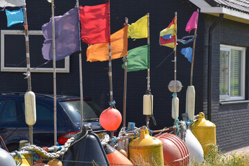 Collection of fishing nets, fenders, buoys and nautical flags.