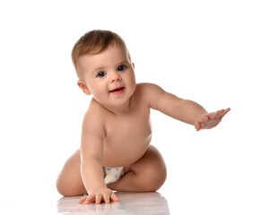 Cute little baby girl infant naked in diaper try to creep on floor smiling and looking aside isolated on white background