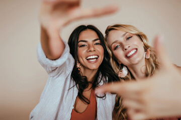 Blithesome blonde girl spending free time with best friend. Wonderful european sisters funny posing...