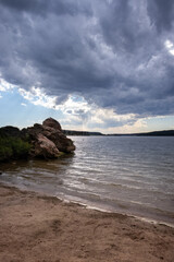 Fototapeta na wymiar Rocks and beach at Keyhole Reservoir in Wyoming with storm clouds moving out. 