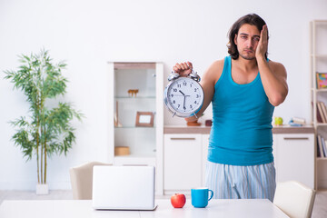 Young man waking up at home