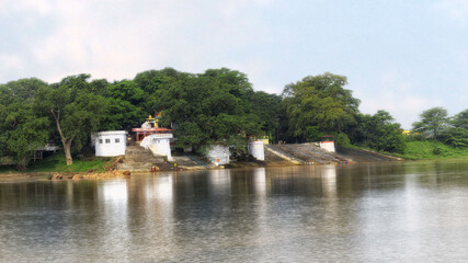 Fototapeta na wymiar An ancient Hindu temple by side of a flowing river