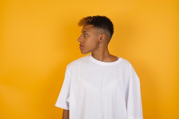 Close up side profile Young African American girl with afro short hair wearing white tshirt...