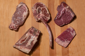 Raw rib eye steak ribs on wooden board