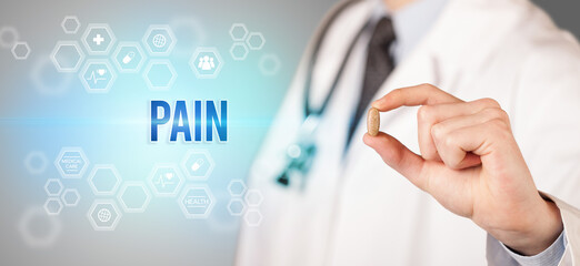 Close-up of a doctor giving you a pill with PAIN inscription, medical concept