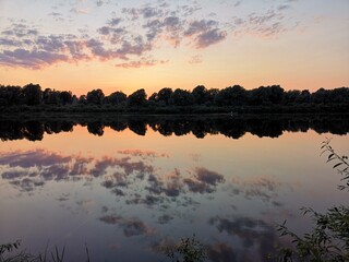 Lake with trees. Summer landscape by the river.Glassy surface of the water