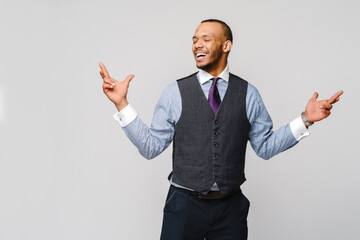 young funny african-american businessman crossing fingers, wishing, hoping for best, miracle over grey background