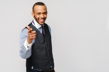 Handsome American-African man pointing you while standing against grey background