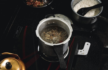 traditional Indian soup preparing in a cocker on a stove.