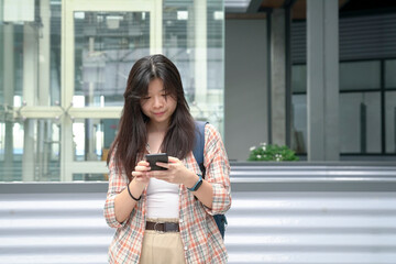 Young Chinese girl using her cellphone to text or message