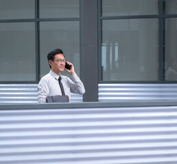 Chinese businessman standing and talking on his cellphone