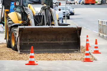 Repair of an asphalt pavement with debris and a bulldozer. Street scene of construction work.